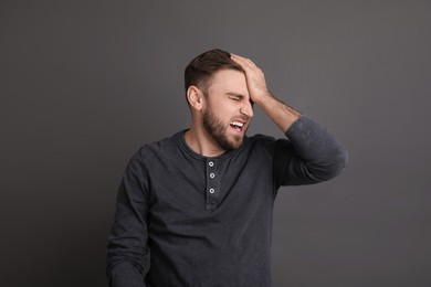 Photo of Portrait of emotional young man on grey background. Personality concept