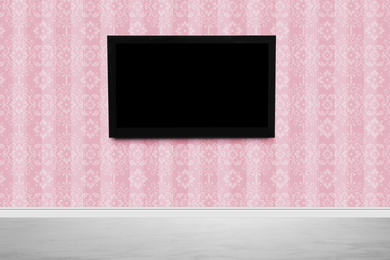 Modern TV on pink wall in room. Space for design