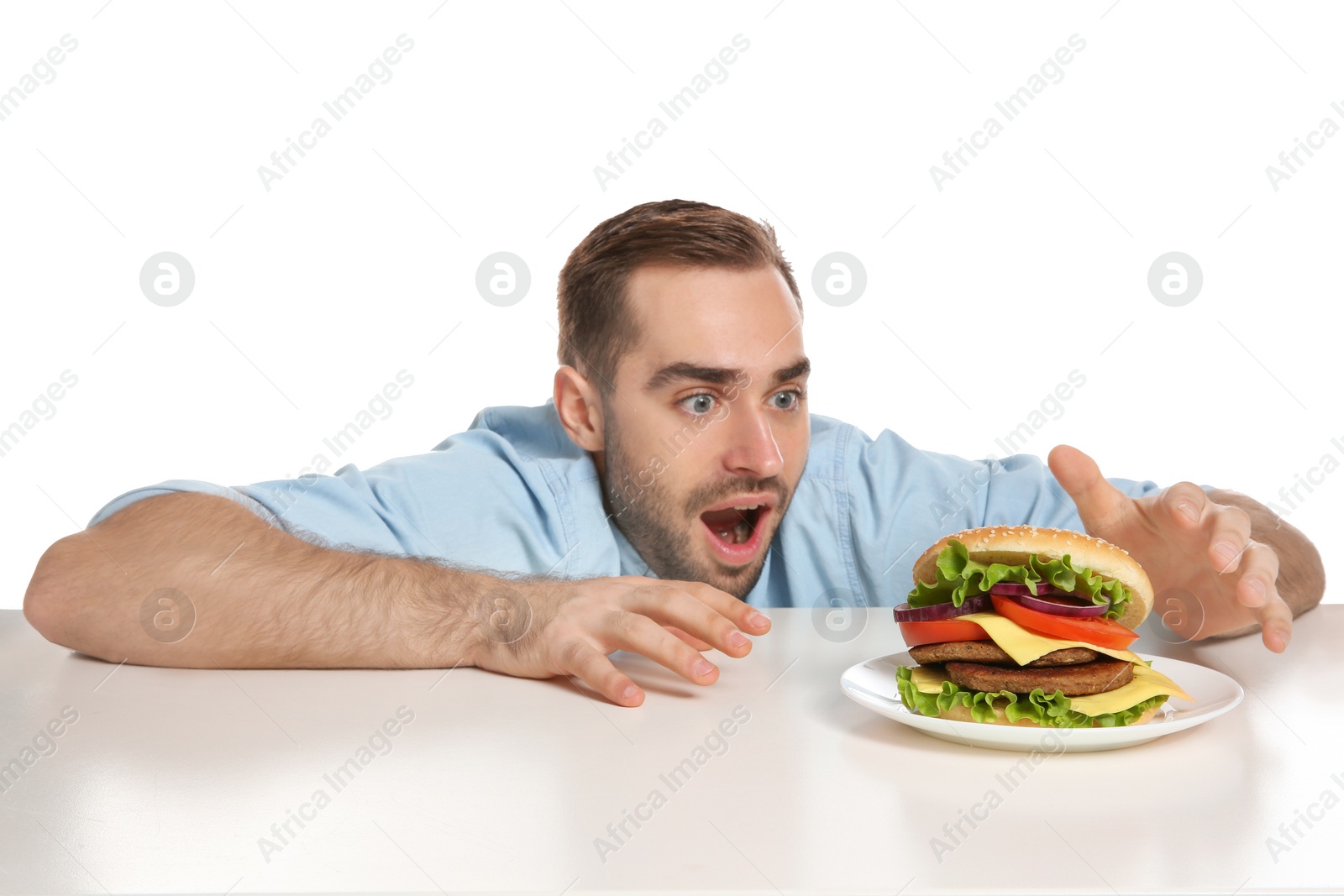 Photo of Young hungry man with tasty burger on white background