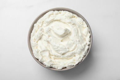 Photo of Bowl of tasty cream cheese on white table, top view