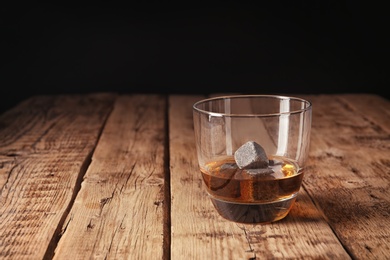 Photo of Glass with liquor and whiskey stones on table