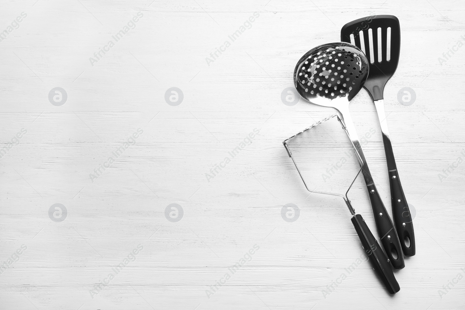 Photo of Different kitchen utensils on wooden background, top view with space for text