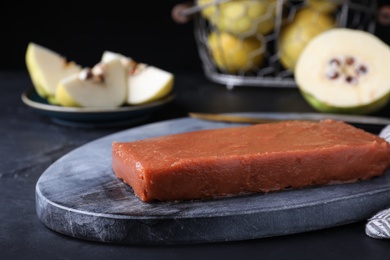 Photo of Delicious quince paste served on black table