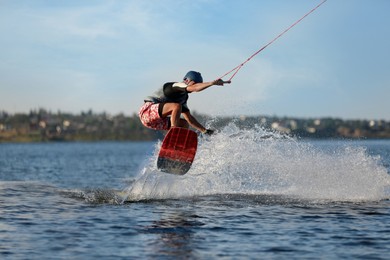 Photo of Teenage wakeboarder doing trick on river. Extreme water sport