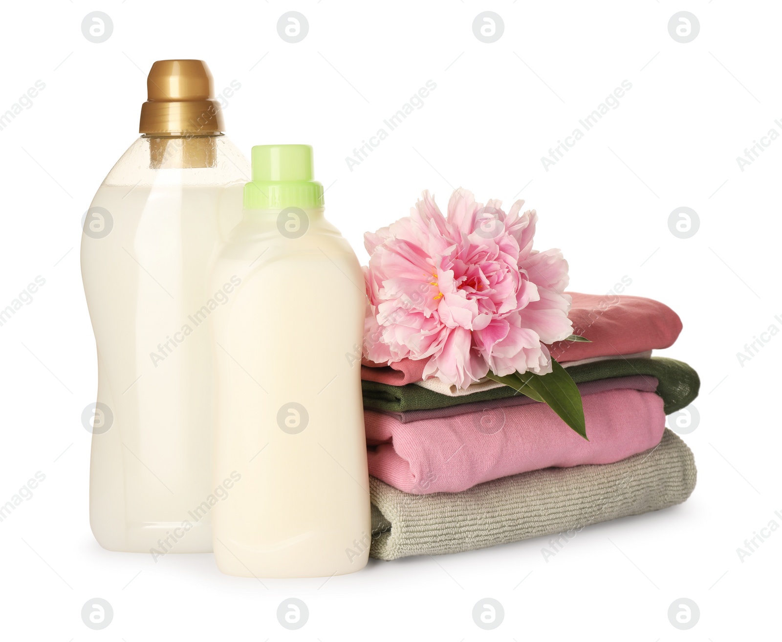 Photo of Bottles of fabric softener, stacked clean clothes and beautiful flower isolated on white