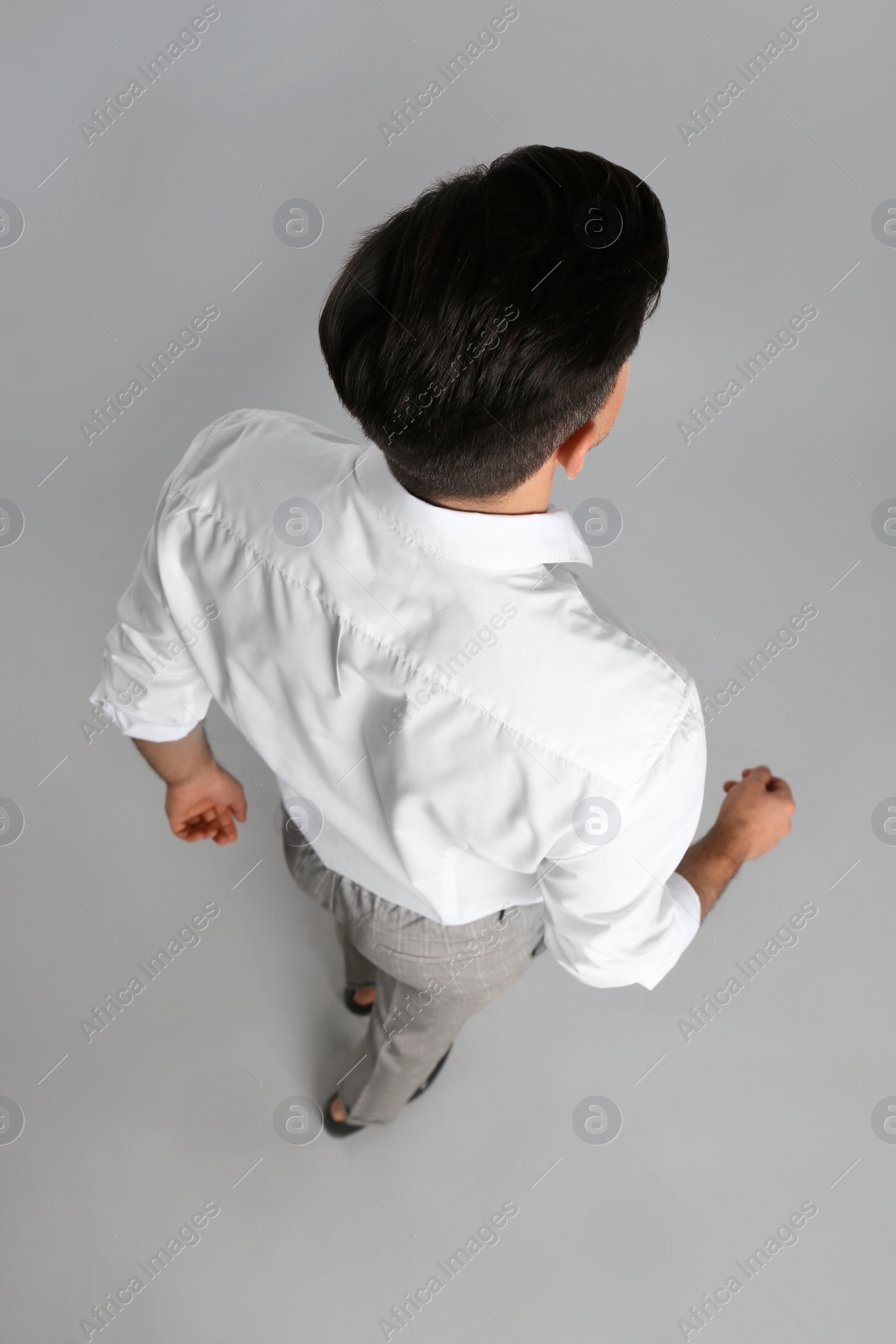 Photo of Businessman in formal clothes on grey background, back view