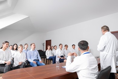 Photo of Doctors giving lecture to audience on medical conference in meeting room