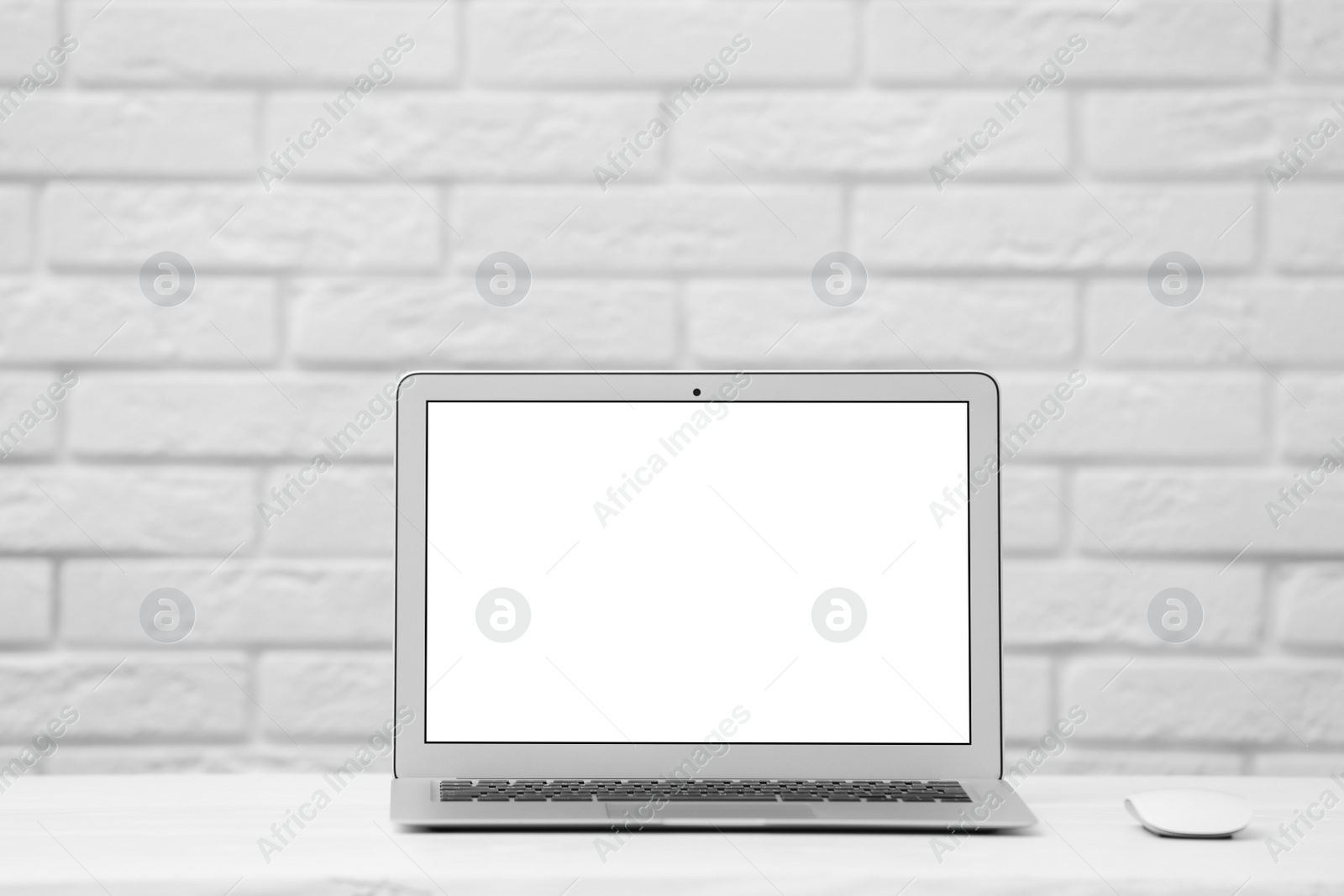 Photo of Laptop with blank screen on table indoors. Space for text