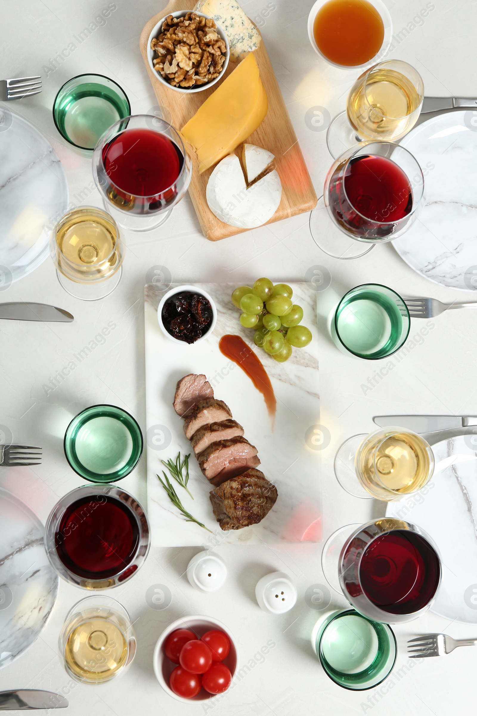 Photo of Wine and snacks served for dinner on light table, flat lay
