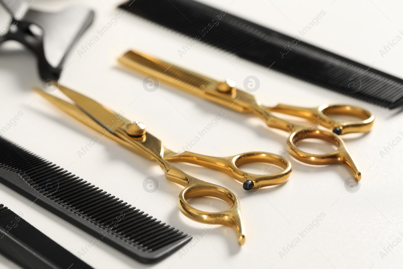 Photo of Hairdresser tools. Different scissors and combs on white table, closeup