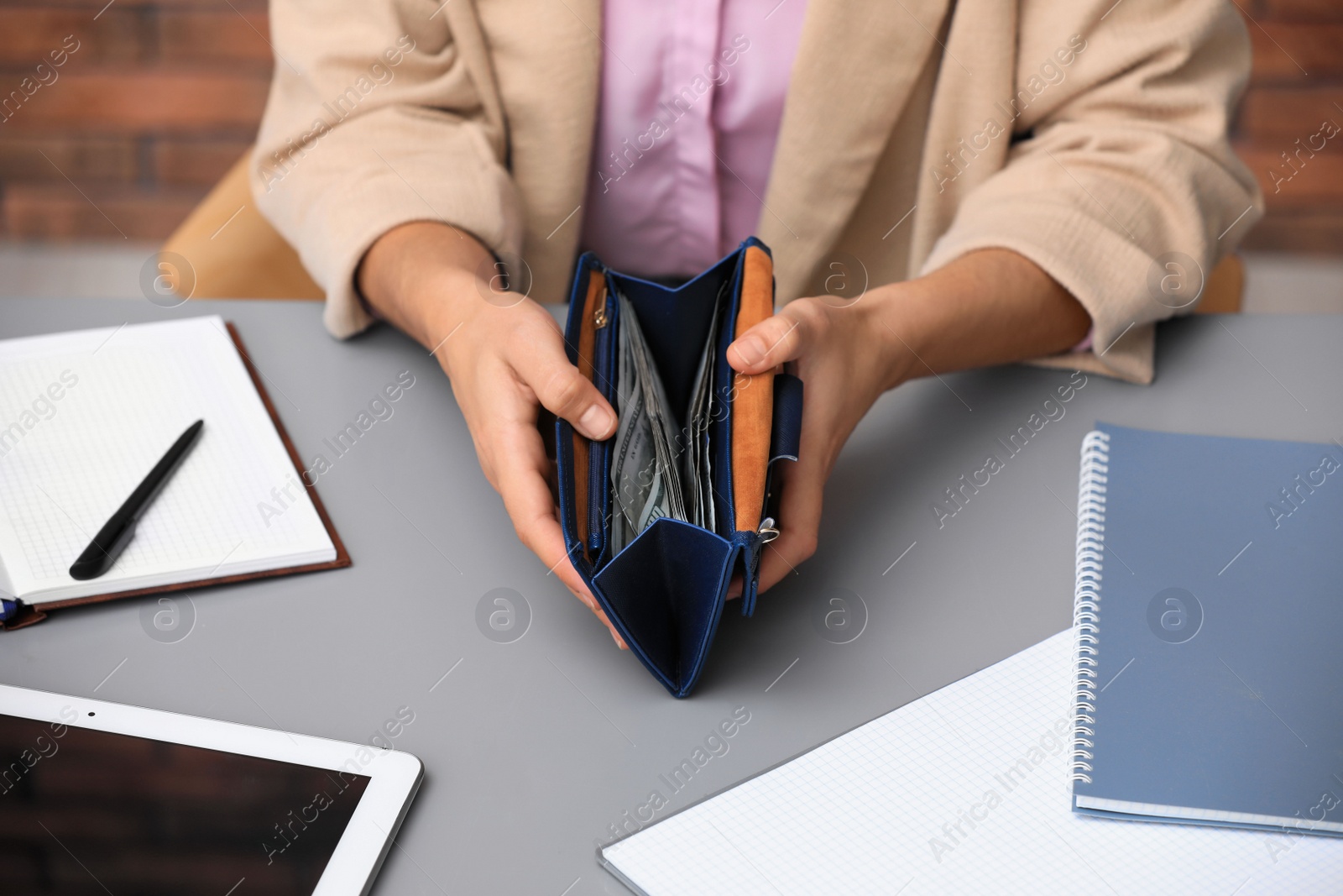 Photo of Woman counting American money at table indoors, closeup