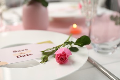 Photo of Romantic table setting. Plate with pink rose on table, closeup