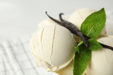 Photo of Delicious vanilla ice cream with mint on table, closeup. Space for text