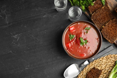 Stylish brown clay bowl with Ukrainian borsch on black table, flat lay. Space for text