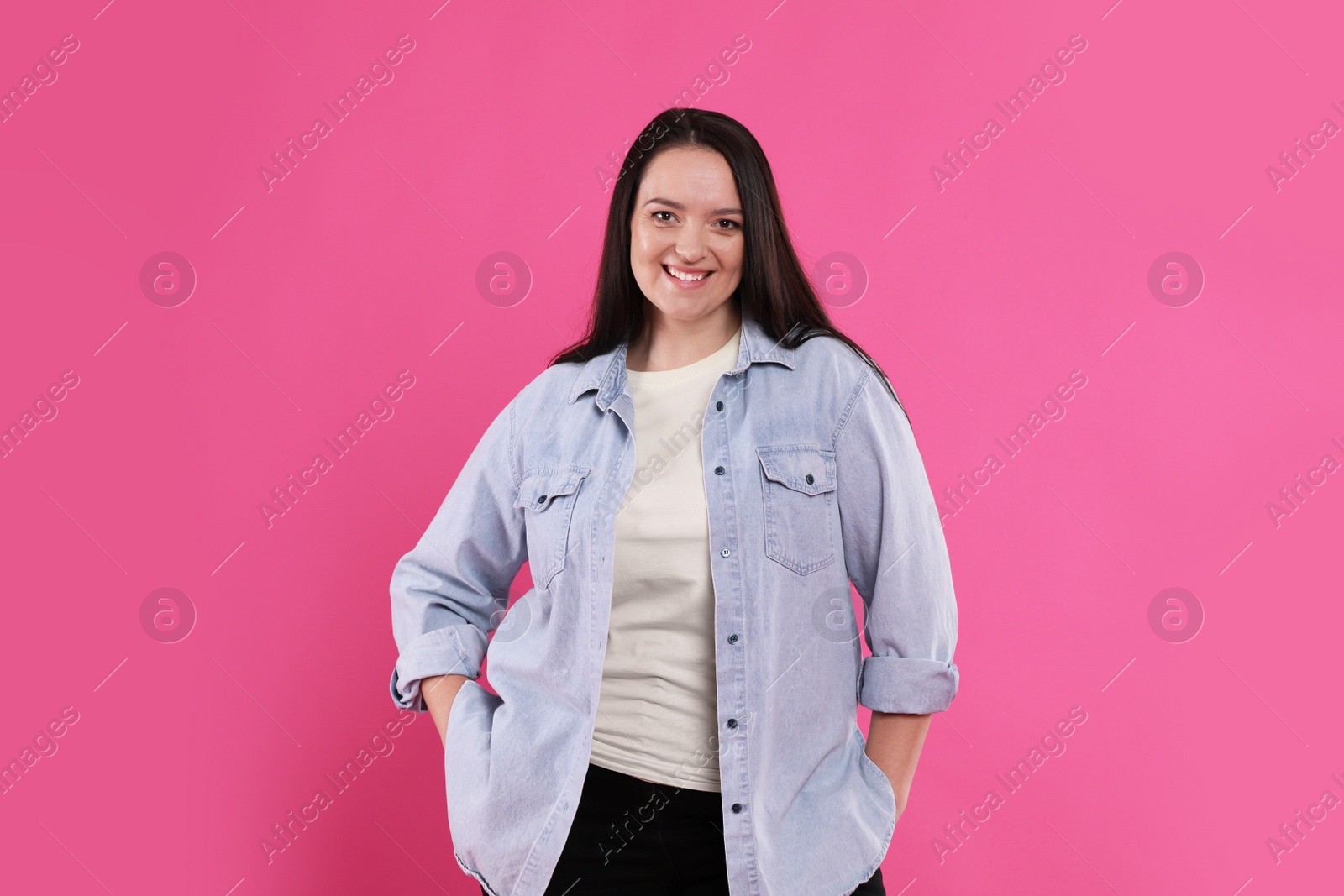 Photo of Beautiful overweight woman with charming smile on pink background