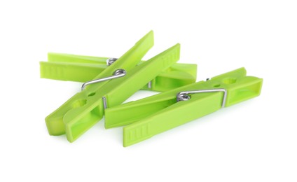 Photo of Bright green plastic clothespins on white background