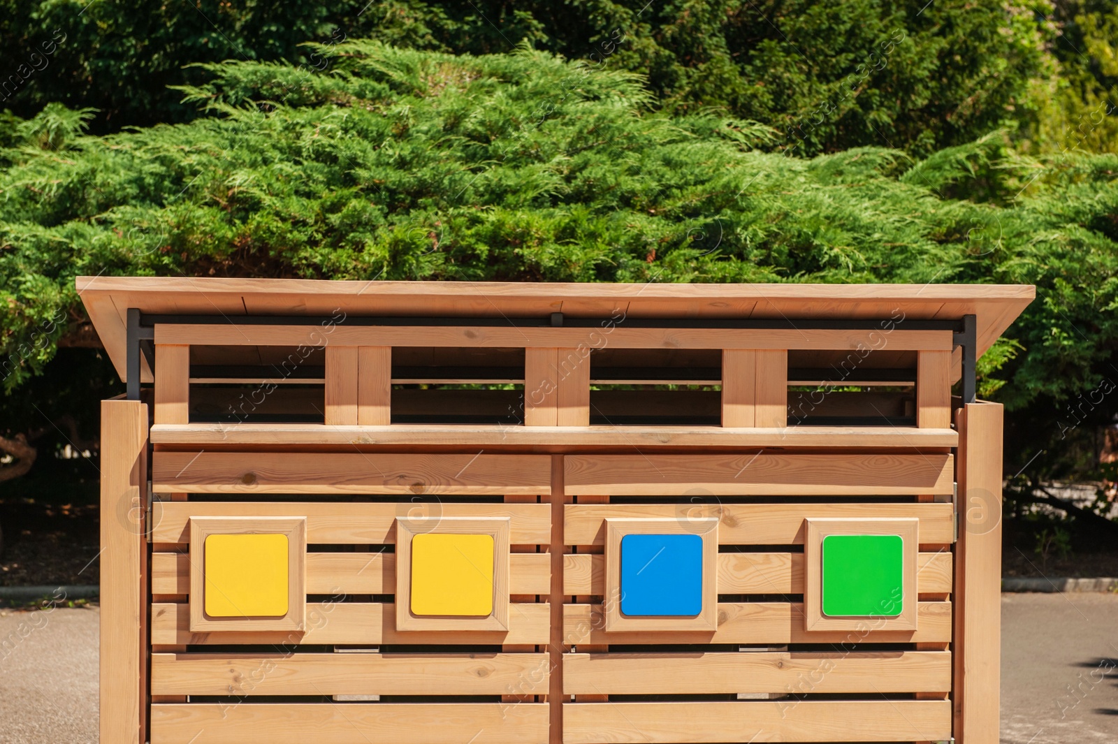 Photo of Wooden recycling bins for waste sorting outdoors