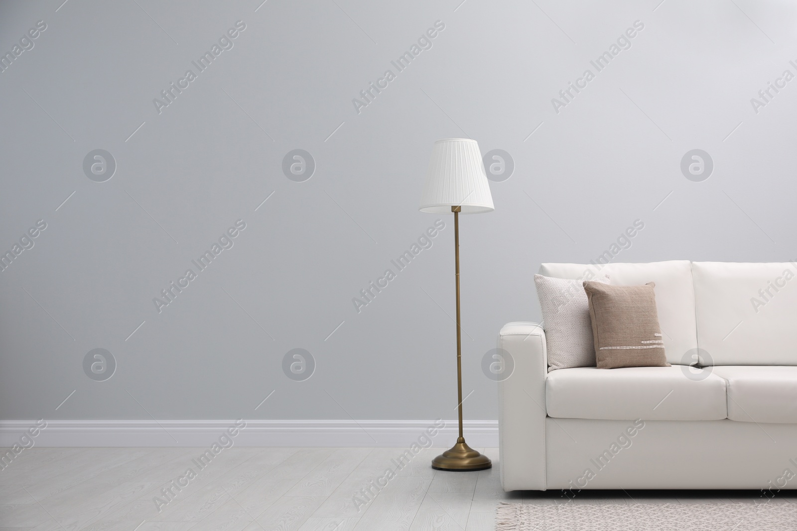 Photo of Simple room interior with comfortable white sofa, space for text