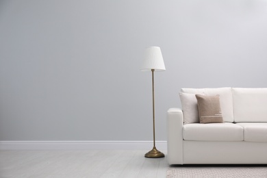 Photo of Simple room interior with comfortable white sofa, space for text