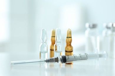 Photo of Syringe with ampules of medicines on white table