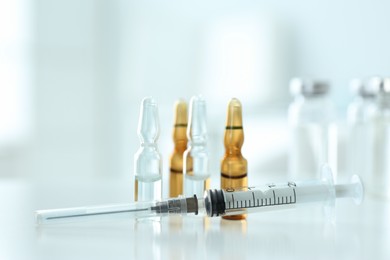 Syringe with ampules of medicines on white table