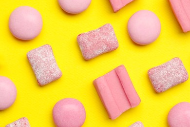Pink bubble gums on yellow background, flat lay