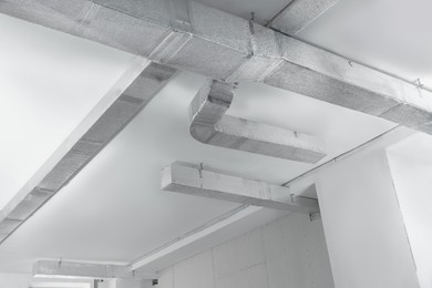 Photo of Ceiling with ventilation system indoors, low angle view