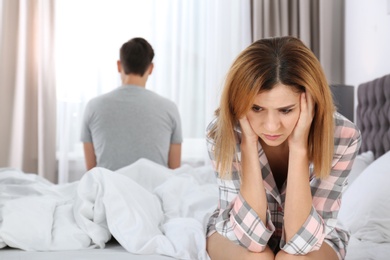 Photo of Couple with relationship problems ignoring each other in bedroom