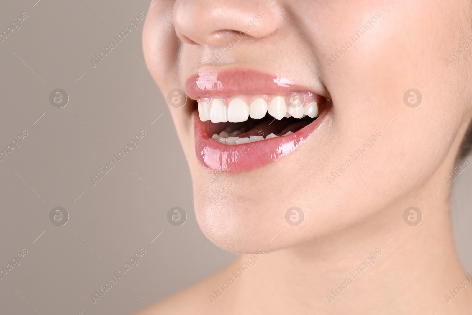 Photo of Beautiful young woman with healthy teeth on color background, closeup