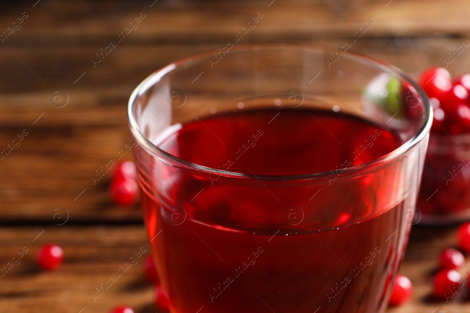 Photo of Tasty cranberry juice in glass on table, closeup