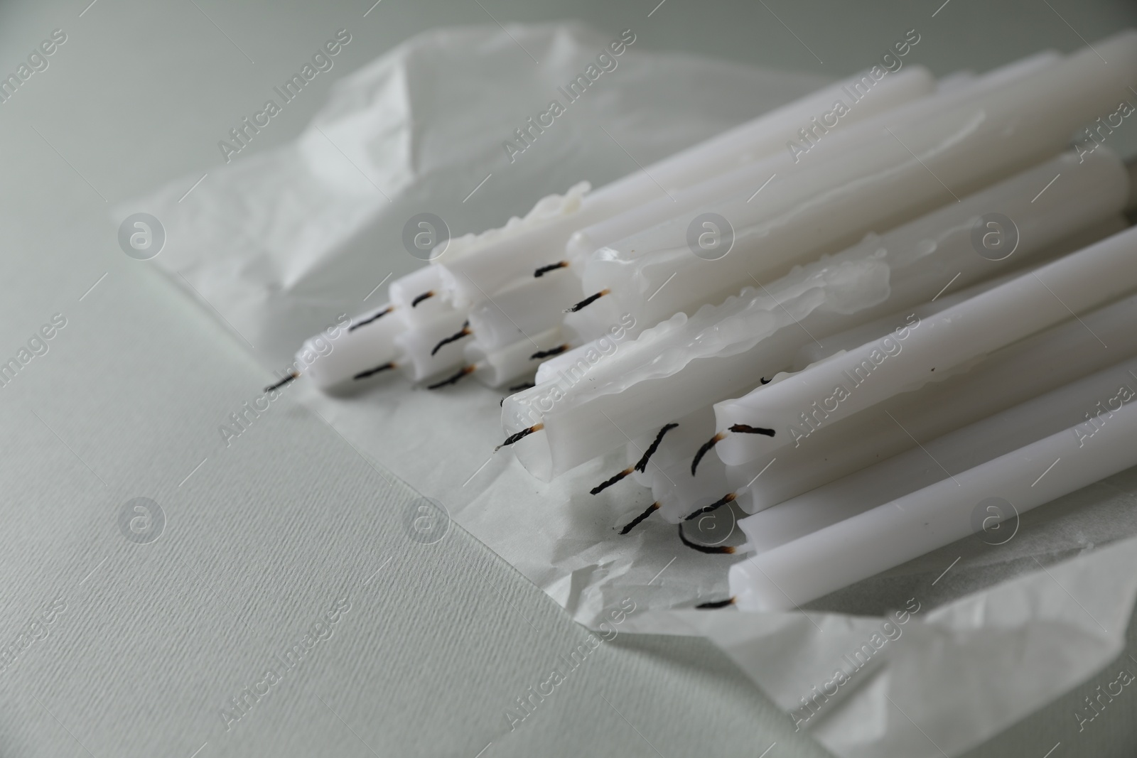Photo of Many church wax candles on light grey table, space for text