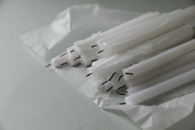 Many church wax candles on light grey table, space for text