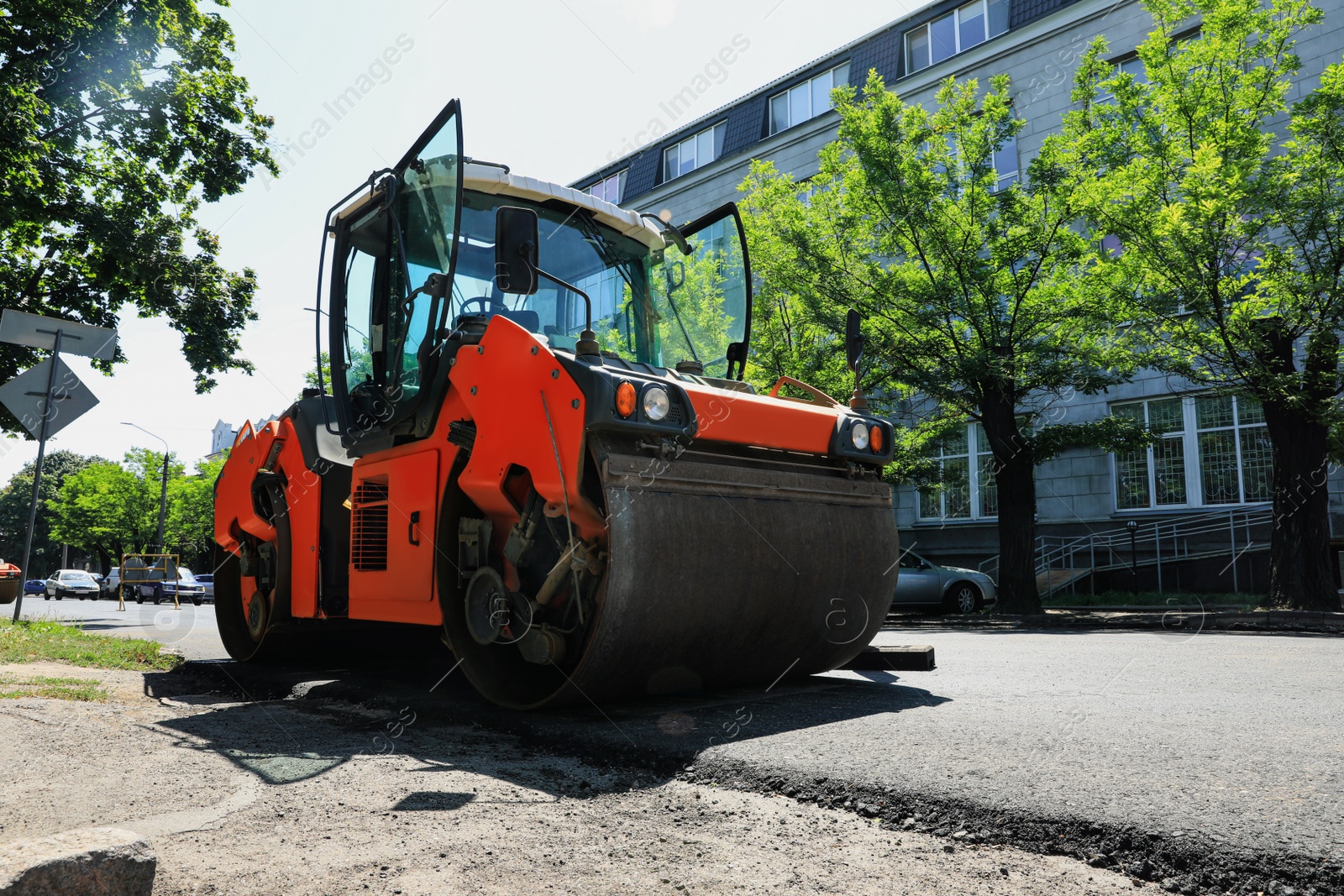 Photo of Roller working on city street. Road repairing