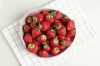 Delicious ripe strawberries in bowl on light grey marble table, flat lay