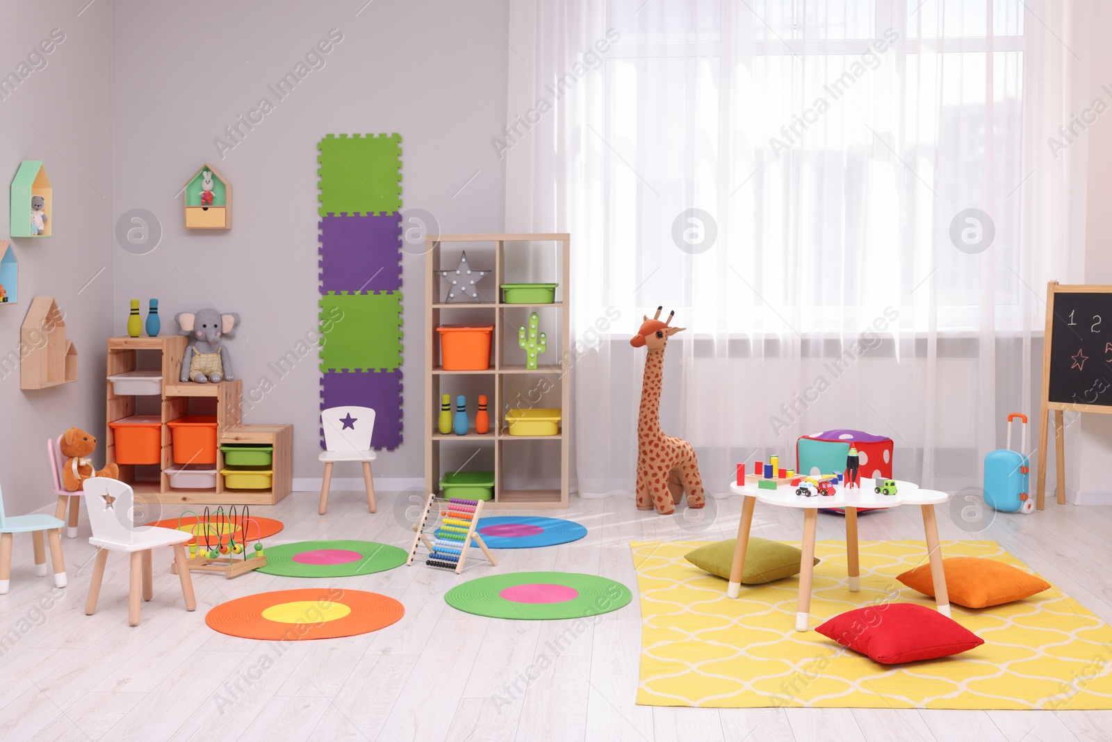 Photo of Child`s playroom with different toys and furniture. Cozy kindergarten interior