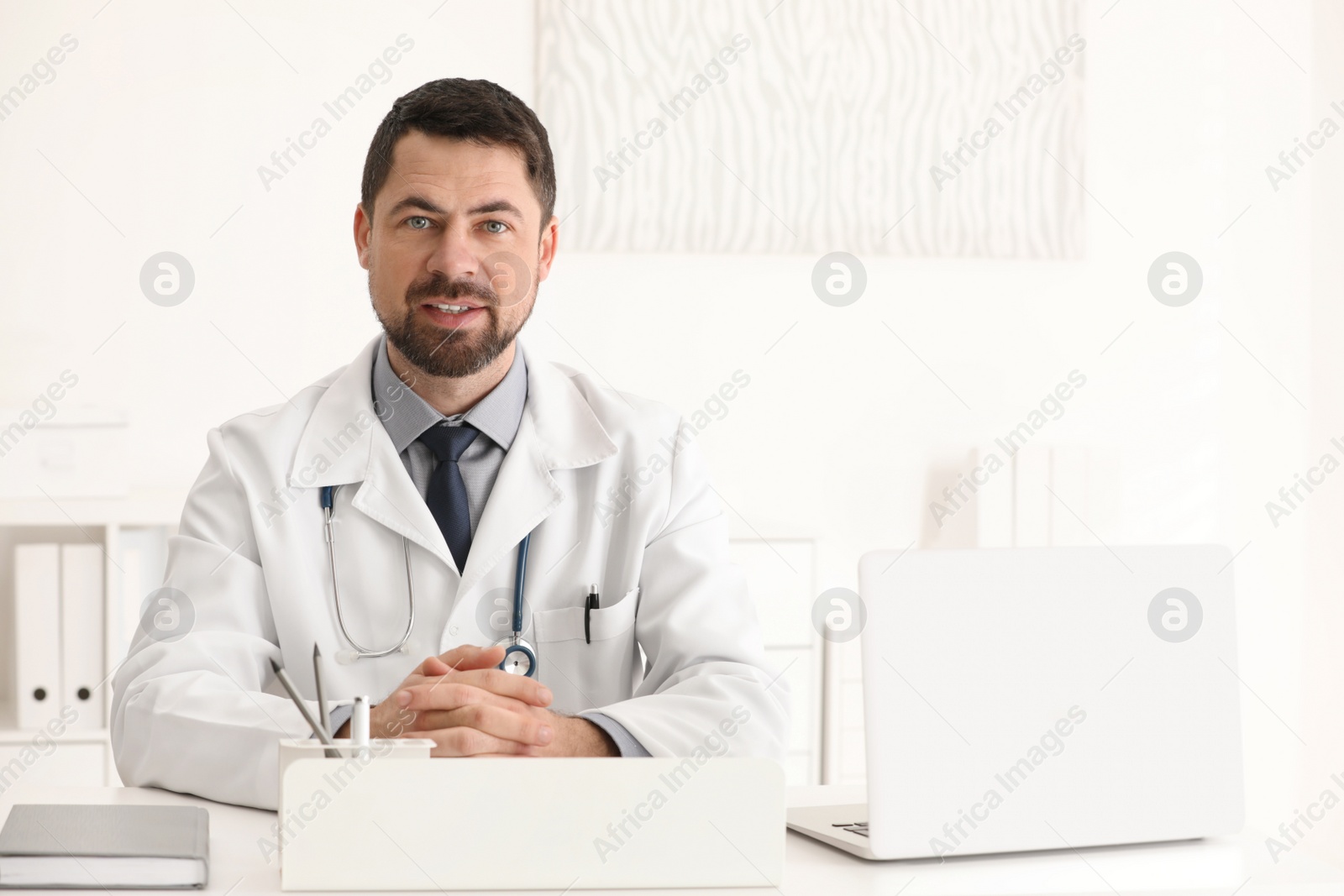 Photo of Portrait of male doctor in white coat at workplace
