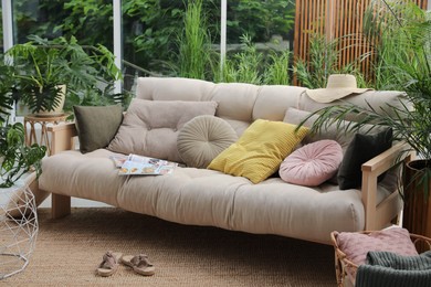 Indoor terrace interior with comfortable sofa and green plants