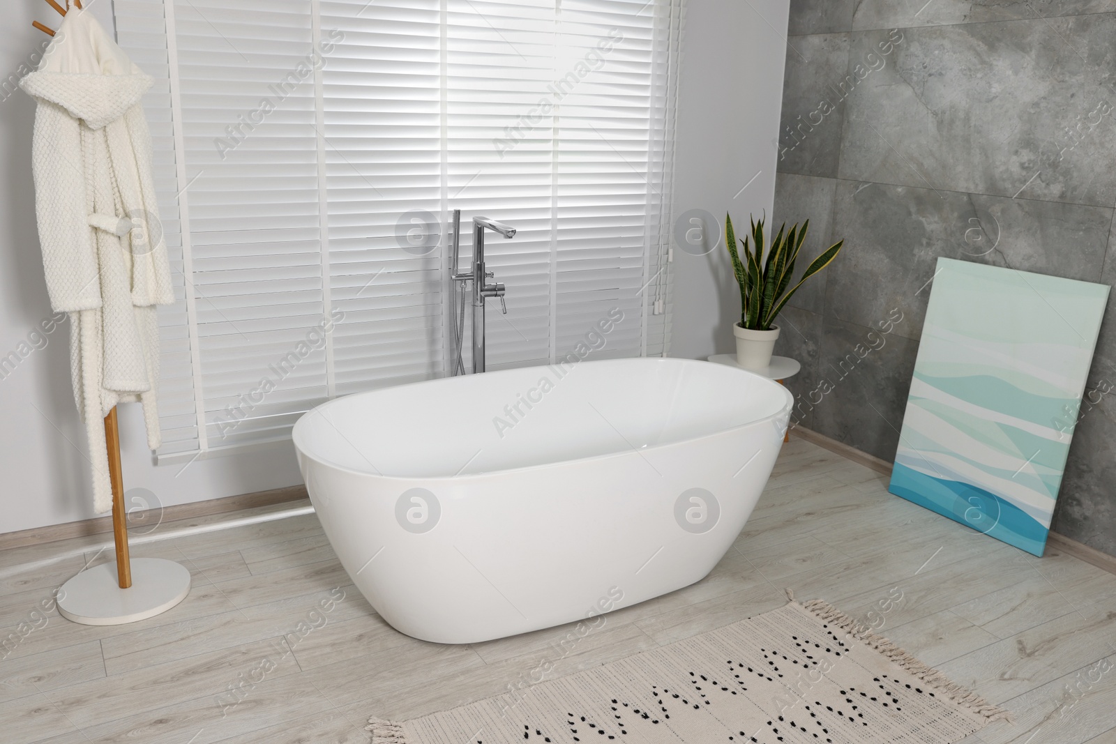 Photo of Stylish bathroom interior with ceramic tub and houseplant