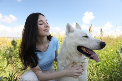 Teenage girl with her white Swiss Shepherd dog in park