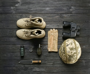 Photo of Set of military equipment and combat boots on wooden background, flat lay