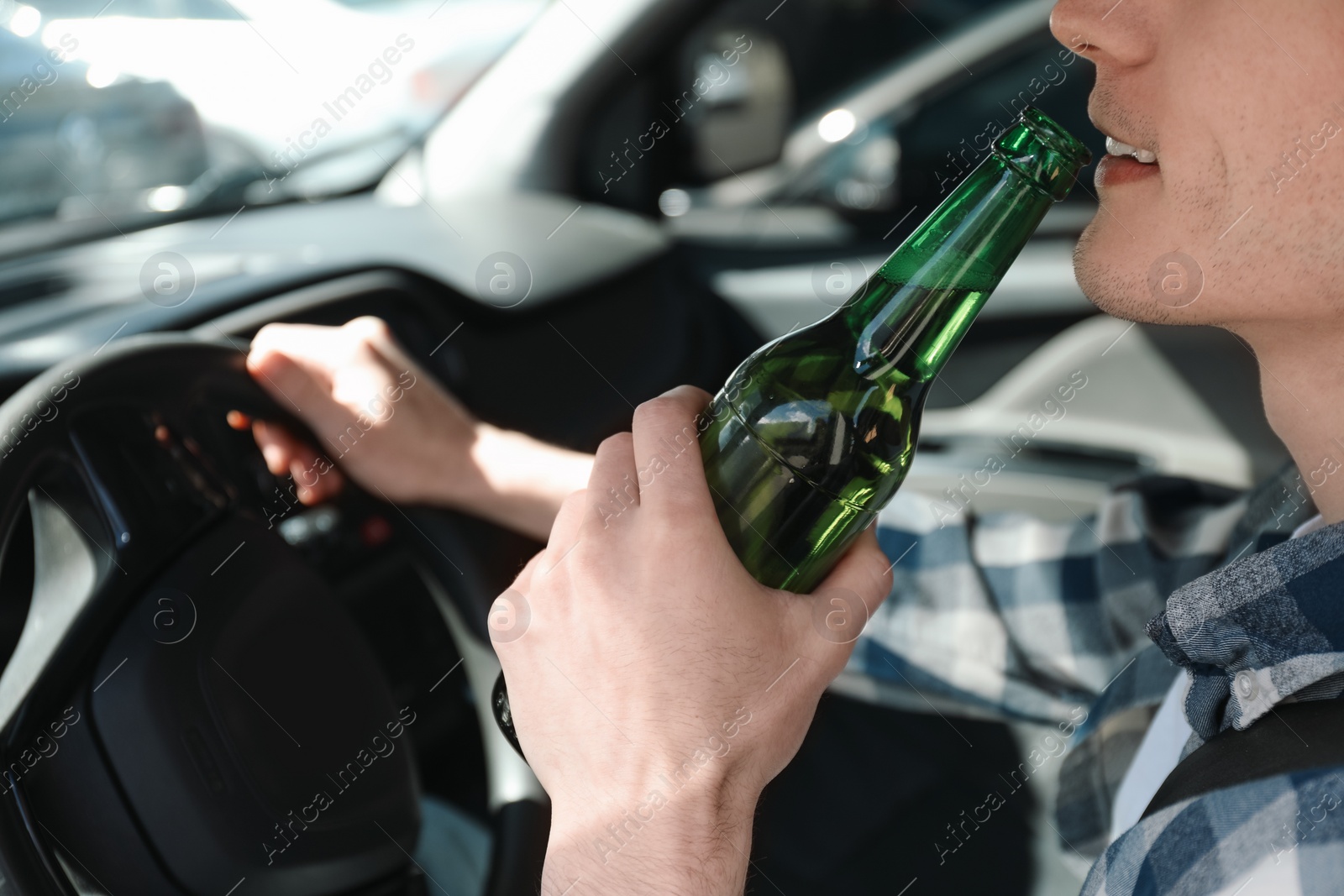 Photo of Man with bottle of beer driving car, closeup. Don't drink and drive concept