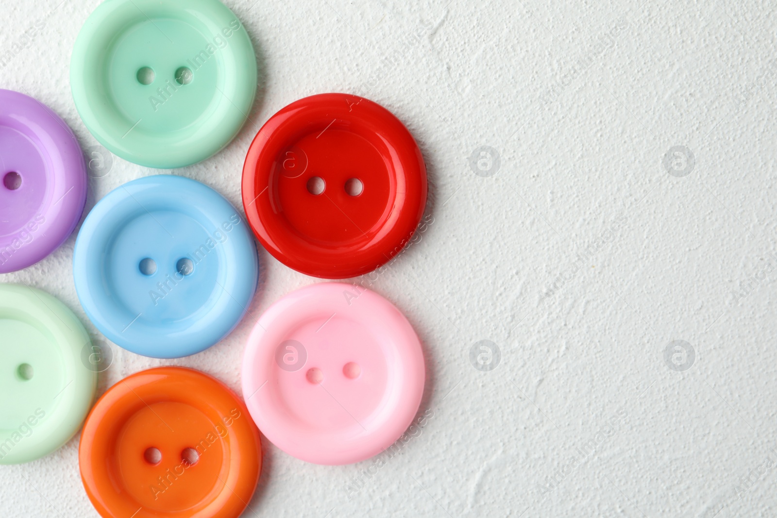 Photo of Many sewing buttons on white background, top view