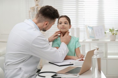 Photo of Pediatrician examining little girl in office at hospital