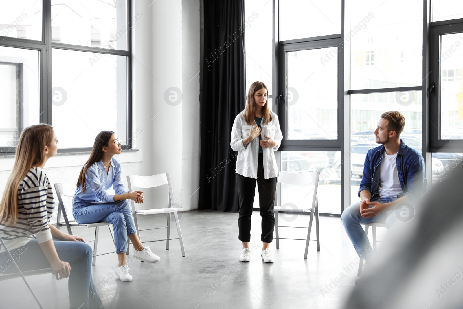 Photo of Psychotherapist working with patients in group therapy session indoors