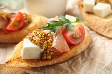 Photo of Delicious bruschettas with prosciutto and cheese served on board