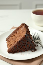 Photo of Piece of delicious chocolate truffle cake and fork on table