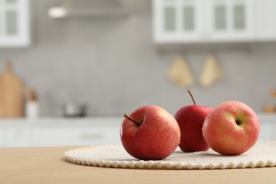 Fresh ripe apples on table in kitchen, space for text