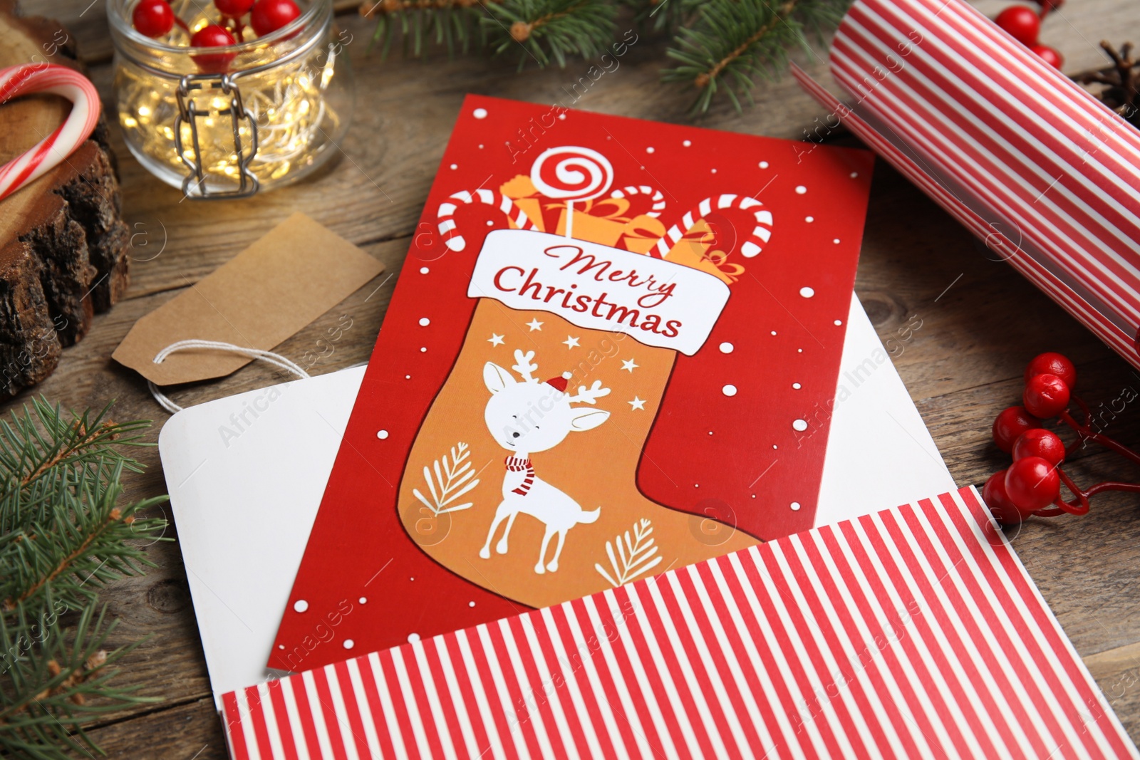 Photo of Christmas card and festive decor on wooden background, closeup