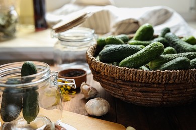 Fresh cucumbers and other ingredients on wooden table, closeup. Pickling vegetables