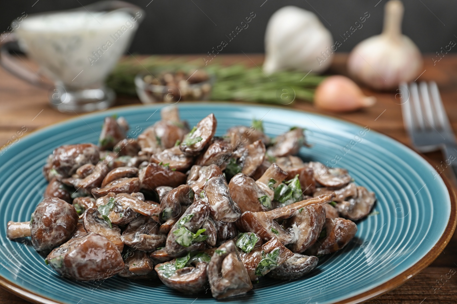 Photo of Plate of tasty fried mushrooms with sauce on table, closeup